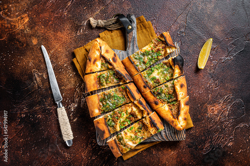 Traditional Turkish baked pide, Middle Eastern snack. Turkish pizza. Dark background. Top view