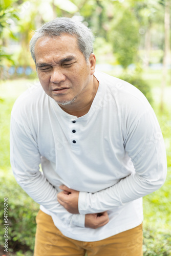 old senior asian man being sick with stomachache concept image for abdominal pain, diarrhea, constipation, food poisoning, gastritis, acid reflux, ulcer, stomach cancer, colon cancer