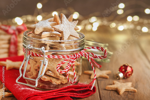 Canvas-taulu Christmas shortbread cookies or gingerbread stars with red ribbon, festive decoration, fir tree,balls and light garland