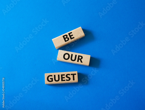 Be our guest symbol. Concept word Be our guest on wooden blocks. Beautiful blue background. Business and Be our guest concept. Copy space