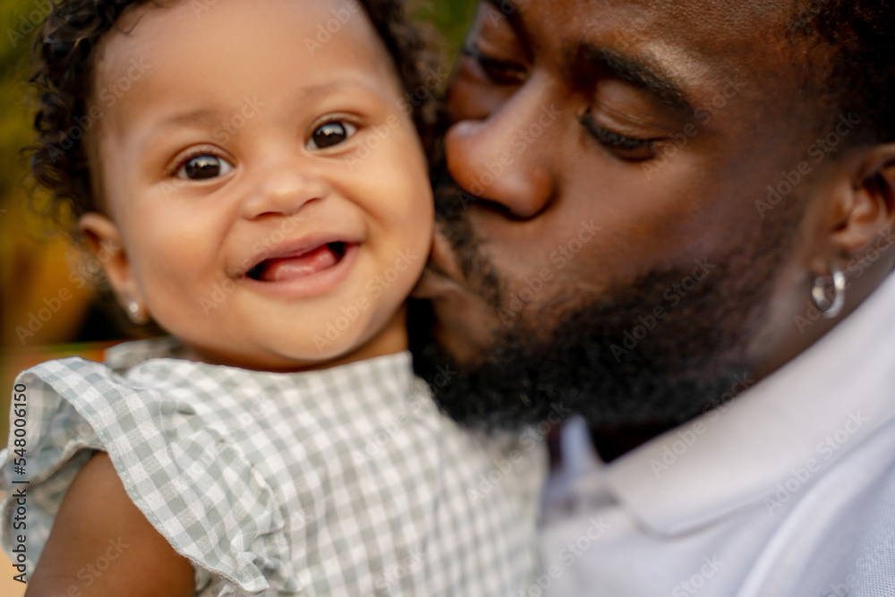 Loving parent kissing his beautiful baby on the cheek Loving parent kissing his beautiful baby on the cheek