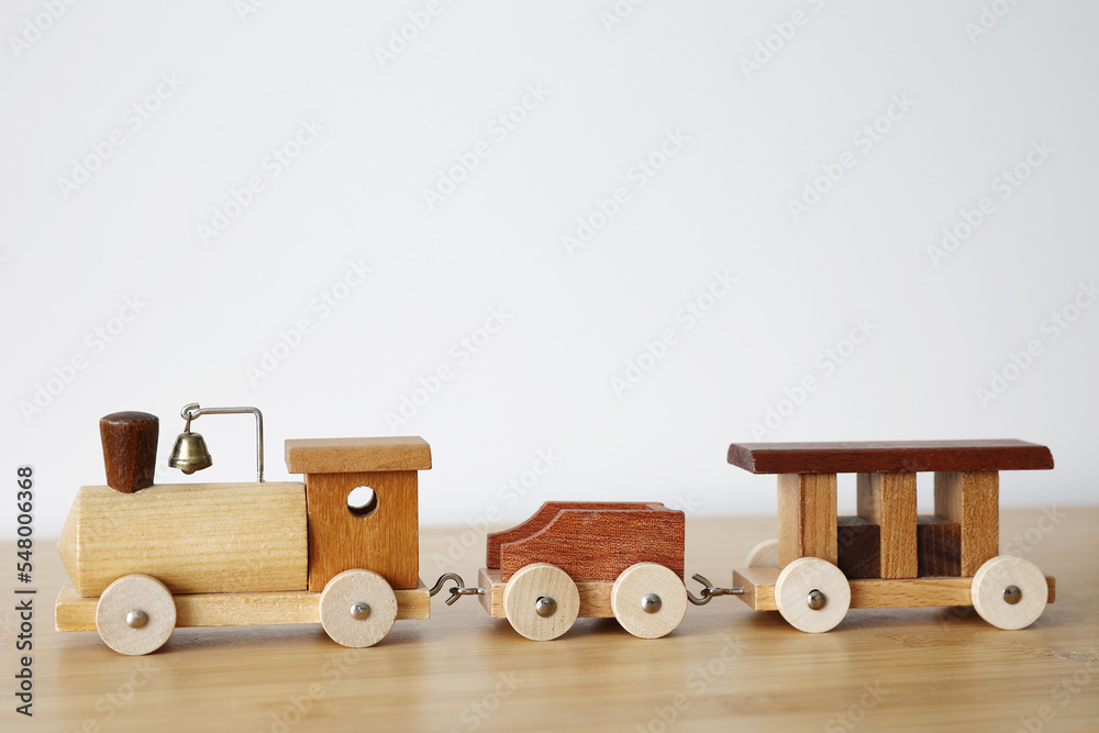 Wooden toy train with one carriage on wooden table with white background and copy Wooden toy train with one carriage on wooden table with white background and copy