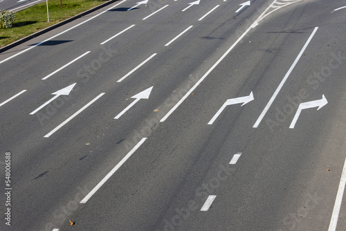 Close-up view of a section of a multi-lane freeway and its exit. Road markings with white paint on asphalt.