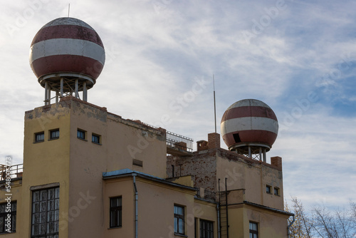 Old abandoned weather station building with large weather radars on the roof