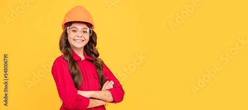 cheerful teen girl wear eyeglasses and helmet. kid future engineer on yellow background. Child builder in helmet horizontal poster design. Banner header, copy space.