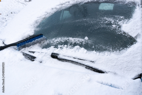 Cleaning car from snow. Concept of bad weather, snow storm