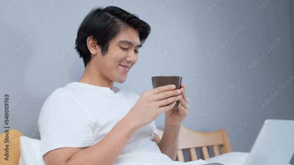 Holiday concept of 4k Resolution. Asian man drinking coffee happily in bedroom. break time from work. fresh scent. Holiday concept of 4k Resolution. Asian man drinking coffee happily in bedroom. break time from work. fresh scent.