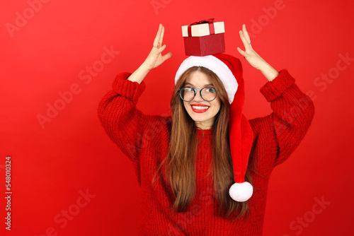 Happy smiling woman with a gift on her head. Christmas celebration, New Year sales and discounts.