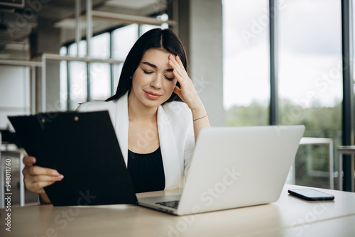 Young business woman working on her laptop in an office