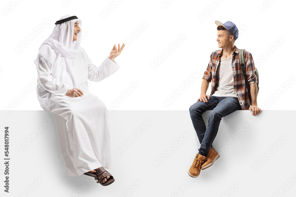Male student sitting on a white board and listening to an arab man