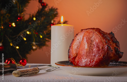 Christmas gammon roast joint resting on a  
table with decorations in the background Fototapeta
