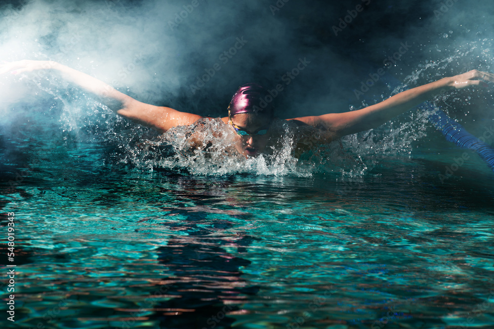 Young woman swimmer training in the pool. Professional swimmer inside the pool.