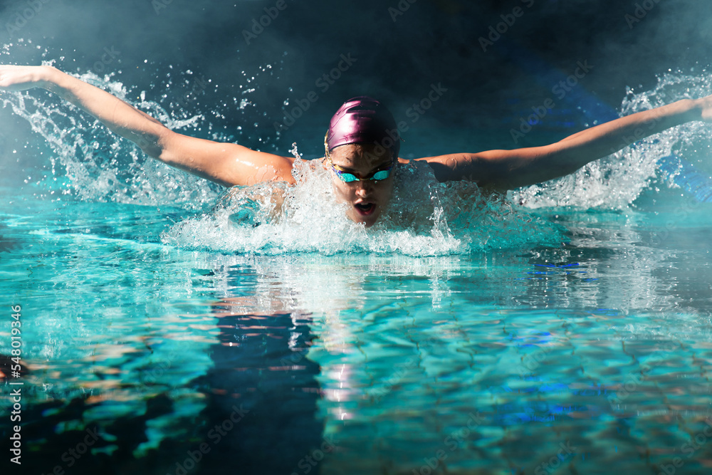 Young woman swimmer training in the pool. Professional swimmer inside the pool.