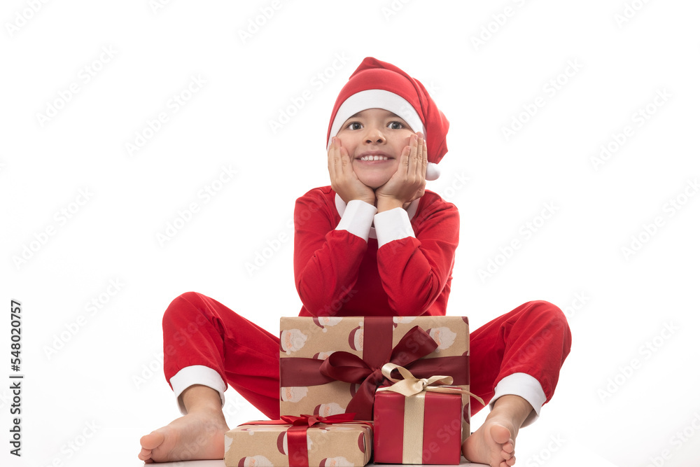 Very adorable young boy with Santa Claus pajama have a lot of fun in photo studio on isolated white background. Very adorable young boy with Santa Claus pajama have a lot of fun in photo studio on isolated white background.