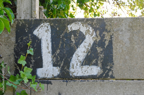 Hand Painted Number '12' on Old Grey Concrete Wall  photo