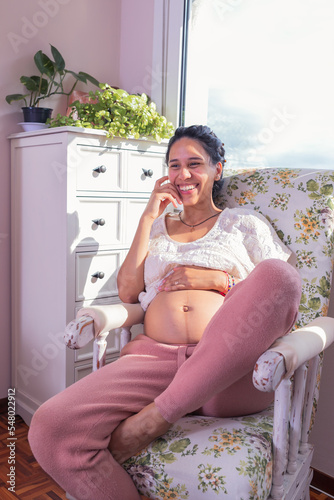 happy pregnant woman with big belly in the window.