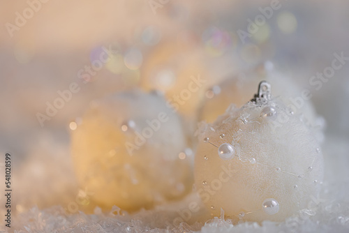 Merry christmas postcard. New Year, beautiful gray blurred background with white balls with pearls and yellow bokeh. Shallow depth of field. Toned image. Copy space. Airy atmosphere. Soft focus.