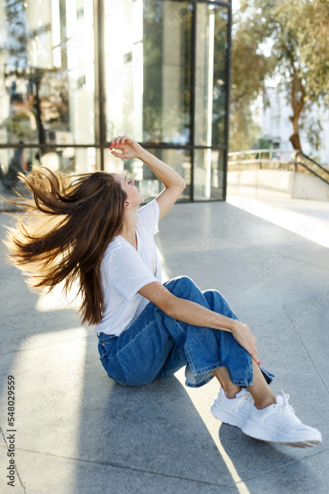 Middle age woman sitting on floor in urban city,wearing casual clothes, happienes concept, sunset light Middle age woman sitting on floor in urban city,wearing casual clothes, happienes concept, sunset light