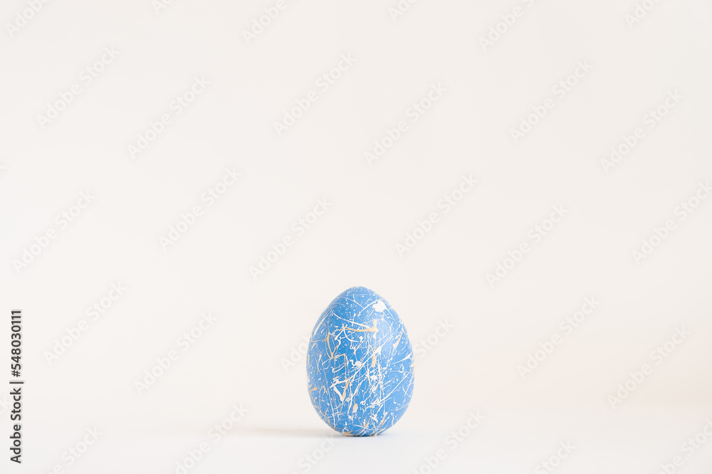 Easter golden decorated egg with paint splashes isolated on white background. Minimal easter concept. Happy Easter card with copy space for text Top view, flatlay