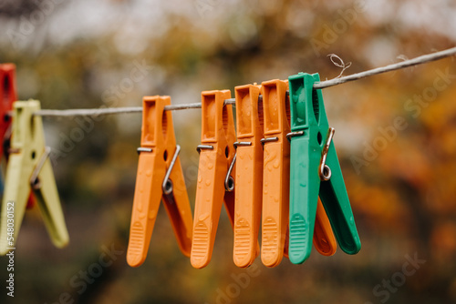 Multi-colored clothespins on a clothesline. Wet clothespins close-up