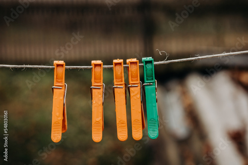 Multi-colored clothespins on a clothesline. Wet clothespins close-up