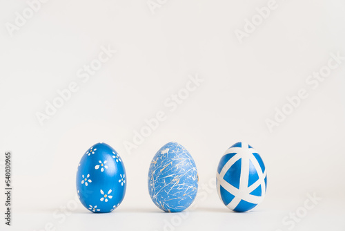 Canvas Print Three Easter golden decorated eggs on white background
