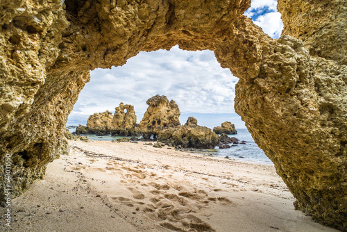 rocks and cliffs on the beach, ocean shore. sandy beach and rocks protruding from the sea in Praia de Sao Rafael. Sunny day, horizontal