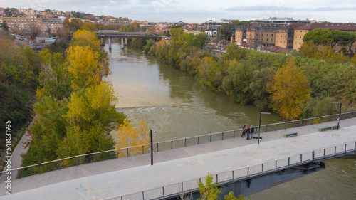 Aerial view over the Tiber River and the Ponte della Scienza, a pedestrian bridge that connects the Lungotevere in Rome, Italy, between the Portuense and Ostiense districts. photo