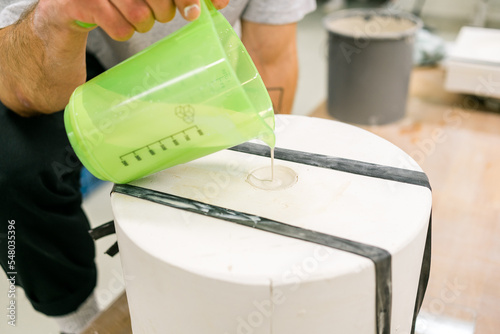 white mould for ceramic slip casting. Puring liquid clay into plaster mould. slipcasting. layers of slip building up along the wall of the mold