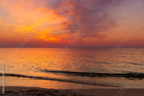 Krajobraz morski. Widok z zachodem słońca i lekkimi falami na piaszczystej plaży. photo