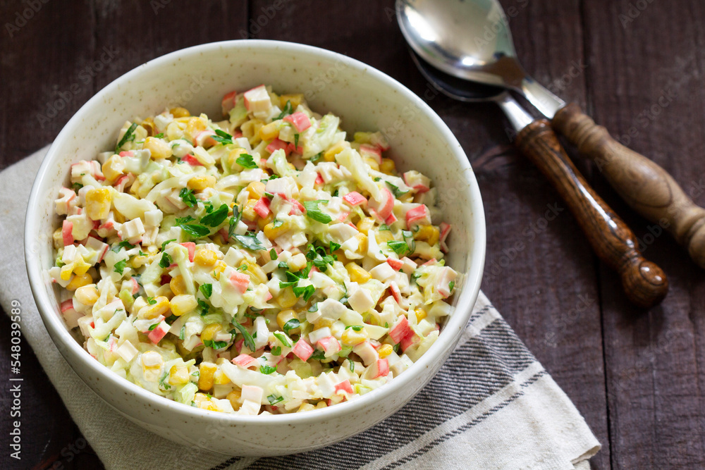 Vegetable salad with crab sticks, dressed with mayonnaise.