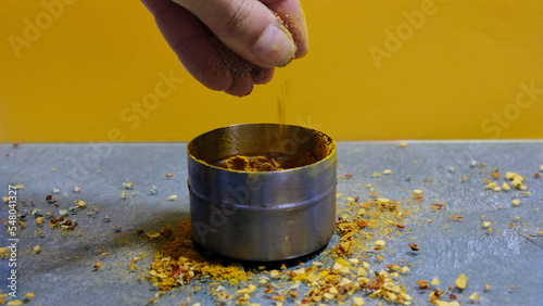 Foto Mano cogiendo curry en un fondo naranja
