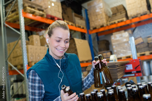 happy female worker on the production line of beer factory