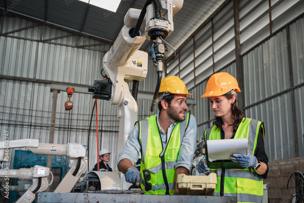 Industrial engineers are in charge of controlling the automated robot arms machine welding robots in industrial manufacturing factory. Industrial engineers are in charge of controlling the automated robot arms machine welding robots in industrial manufacturing factory.
