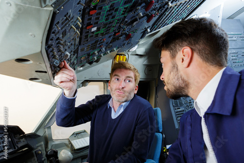 two pilots communicating and discussing in the cockpit © auremar