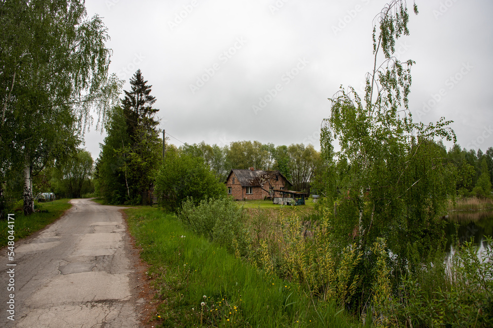 old brick house near pond in overcast spring day