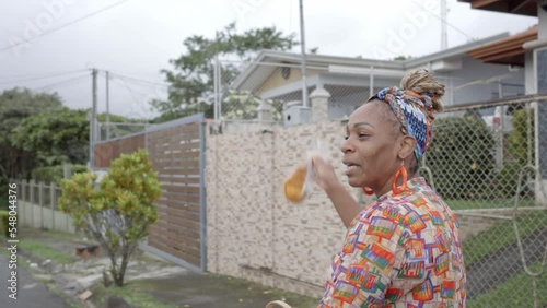 Imagen en video de una mujer afro caribeña con ropa colorida vendiendo en la calle sus productos en una bicicleta  photo