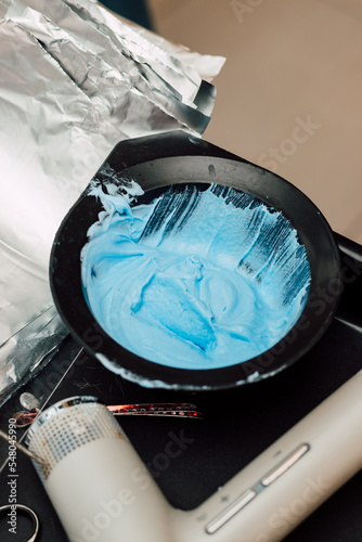 A professional hairdresser mixes a dye with an oxidizer. Hair coloring