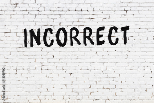 Inscription incorrect painted on white brick wall