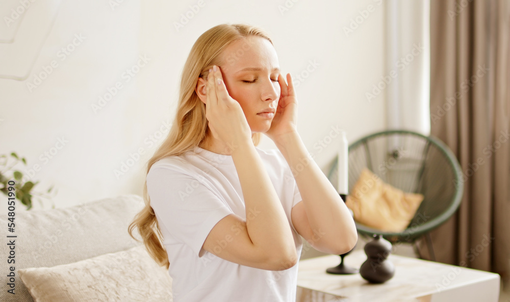 Stressed unhealthy woman feeling tired have terrible strong headache pain. Female suffering from migraine massaging temples. Stressed unhealthy woman feeling tired have terrible strong headache pain. Female suffering from migraine massaging temples.