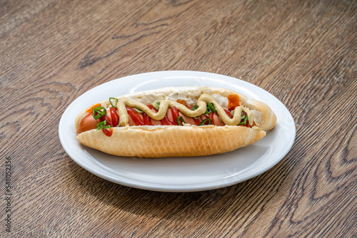 hot dog with mustard ketchup and spring onion