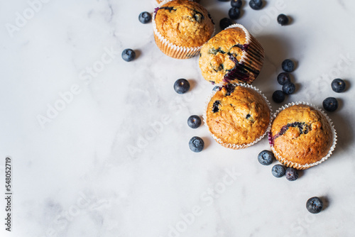 Blueberry muffins on a white marble background.