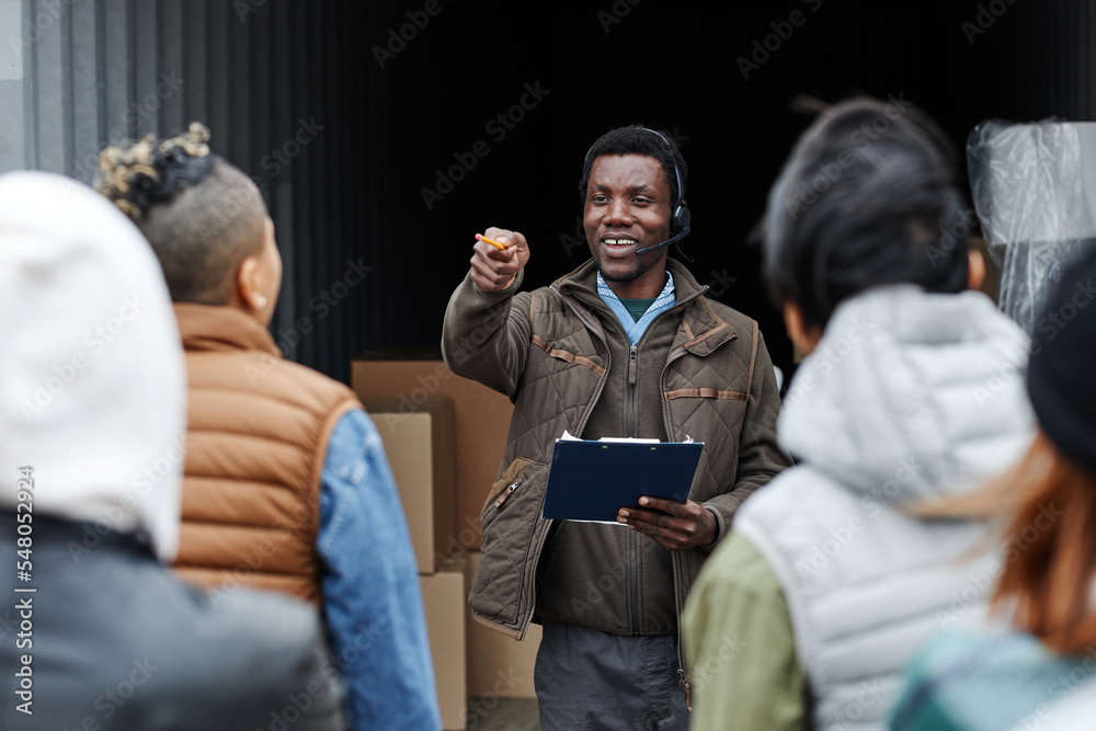 Φωτογραφία Waist up portrait of smiling auctioneer standing by container at shipping port a