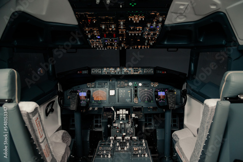 Fototapeta Naklejka Na Ścianę i Meble -  Empty pilot Cockpit with switched on Flight Deck dashboard in night, without people