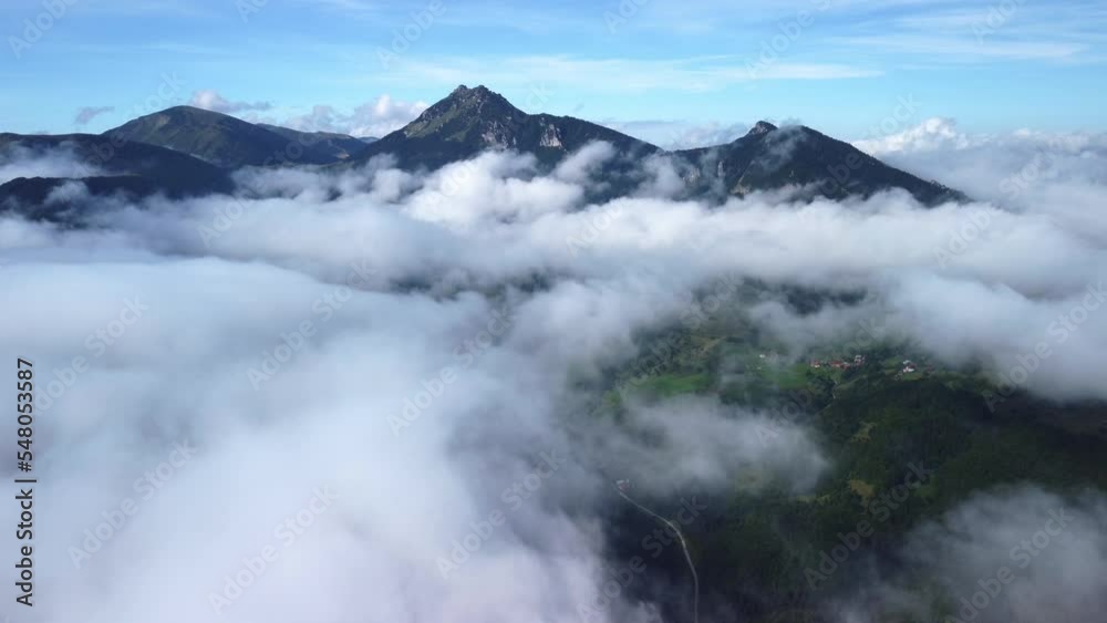 Beautiful summer mountain landscape from a bird's eye view above the clouds. White low clouds Beautiful summer mountain landscape from a bird's eye view above the clouds. White low clouds