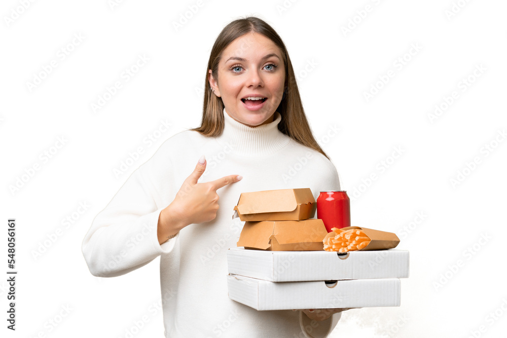 Young beautiful blonde woman holding takeaway food over isolated background with surprise facial expression Young beautiful blonde woman holding takeaway food over isolated background with surprise facial expression