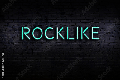 Neon sign. Word rocklike against brick wall. Night view photo