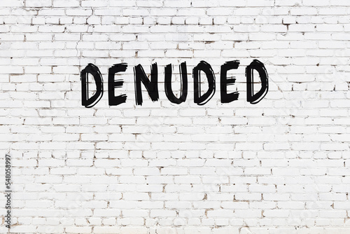 White wall with black paint inscription denuded on it