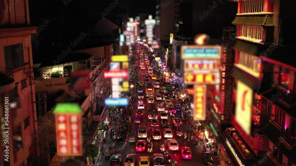 Aerial over a traffic cars and a crowd of chinatown bangkok walking street at night.
Aerial over a traffic cars and a crowd of chinatown bangkok walking street at night.