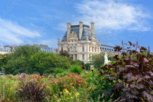 Colourful flowers and plants in the Tuileries Garden, view of Louvre building. Paris, France.  photo